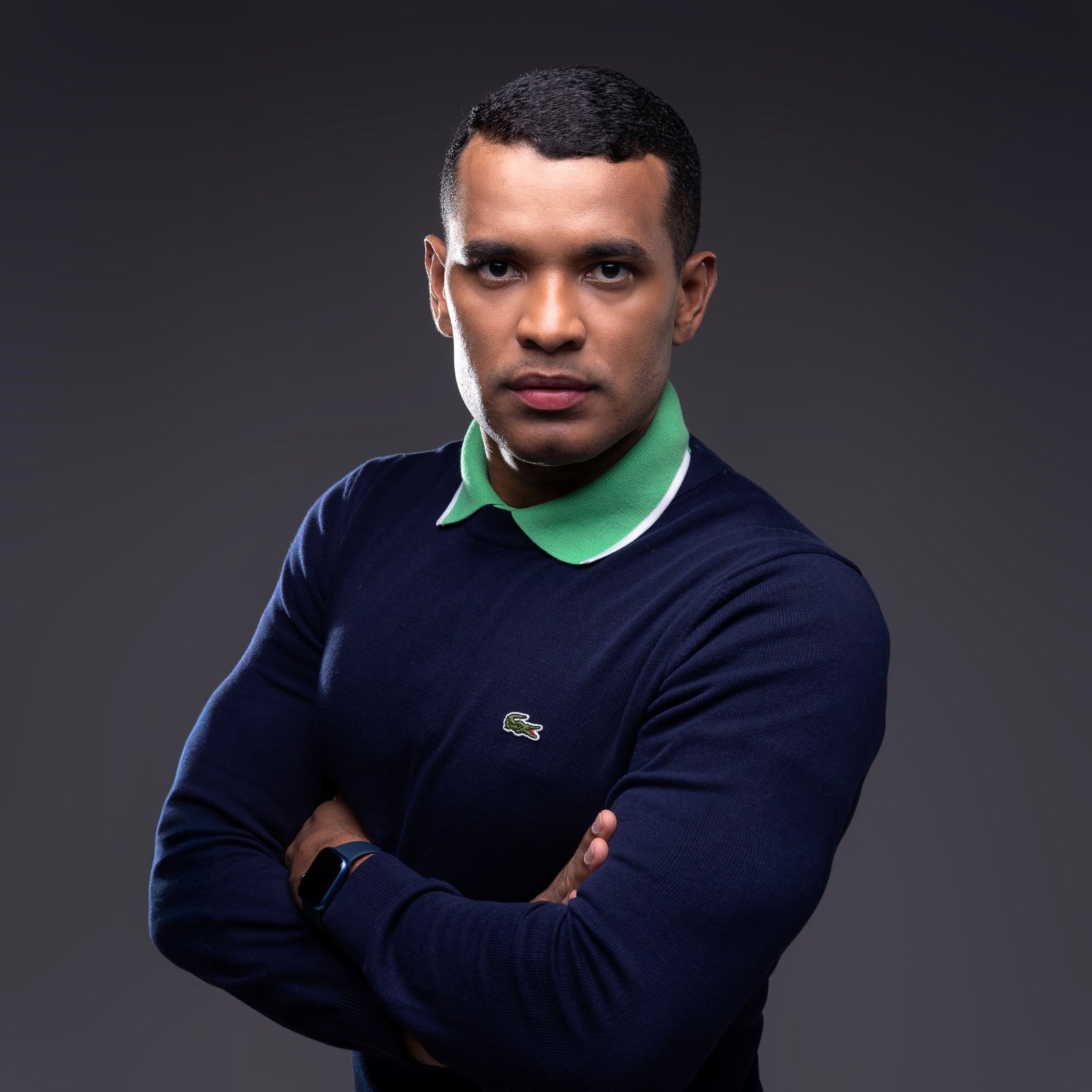 Dr. Wanderson Rodrigues, cirurgião-dentista, de braços cruzados em retrato de estúdio